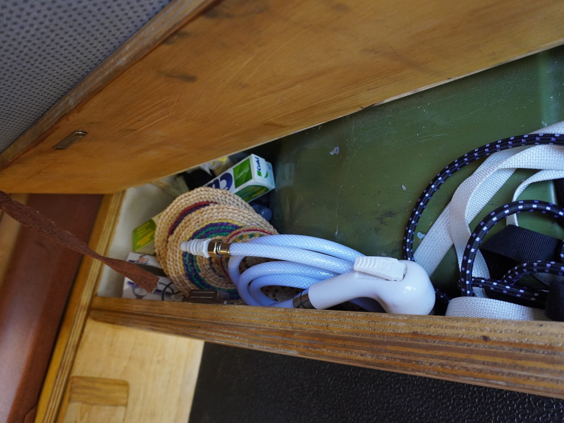 Under-bench storage compartment with hose and straps