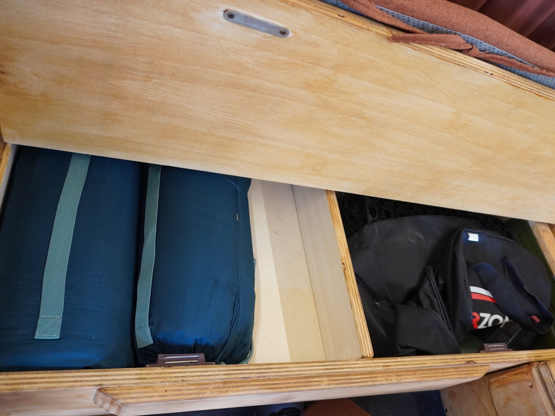 Bench storage with bedding rolls and travel bags